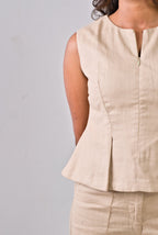 Beige sleeveless top worn by a person on a plain background